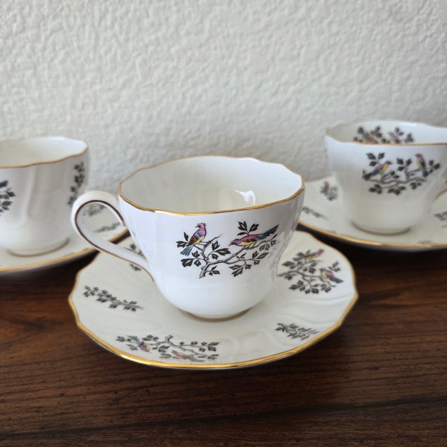 A charming set of four vintage Spode fine bone china teacups with matching saucers, crafted in England in the discontinued...
