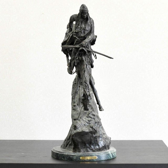 This Bronze Buffalo Signal Sculpture After Frederic Remington is a dramatic Western-inspired work that captures the...