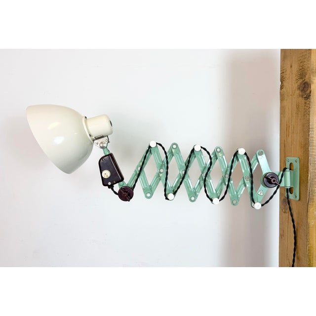 This vintage industrial scissor lamp was produced by veb zweckleuchtenbau dresden in former east germany during the 1950s....