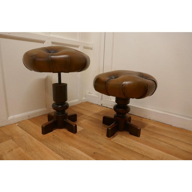 A Pair of Sturdy French button leather Swivel piano stools. These are sturdy heavy quality pieces, the stools have a heavy...