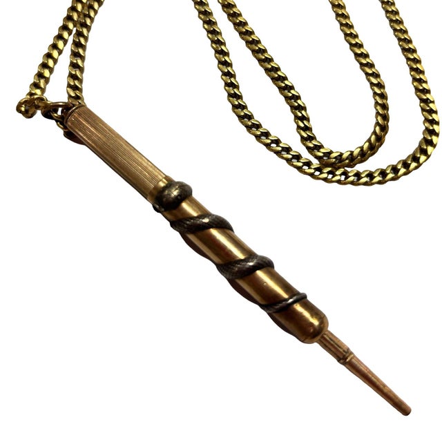 This elegant 18k plated Victorian-era mechanical fob pencil ion a gold plated necklace. Crafted with a classic spiral-...