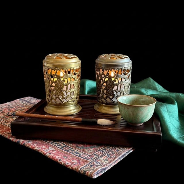 Pair of vintage brass Chinese immortal lanterns featuring intricate pierced figural scenes with scholars and bamboo...