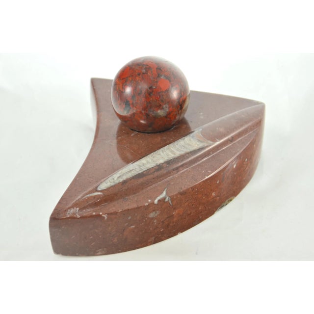 Large vintage artisan carved iron red fossil stone wedge shape stand accentuates the extinct Devonian Period marine animal...