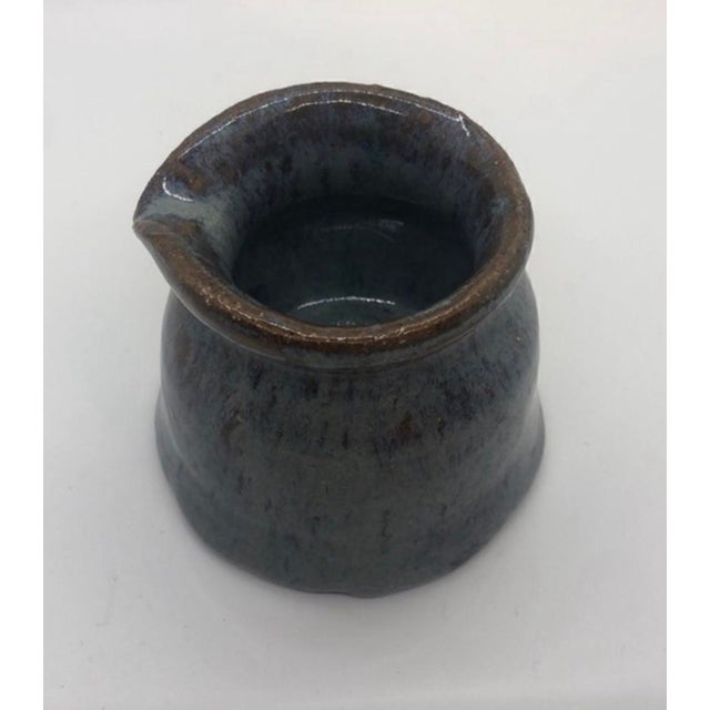 This product is a vintage 3" glazed artist signed pottery pitcher made in the United States. It is designed as a syrup or...