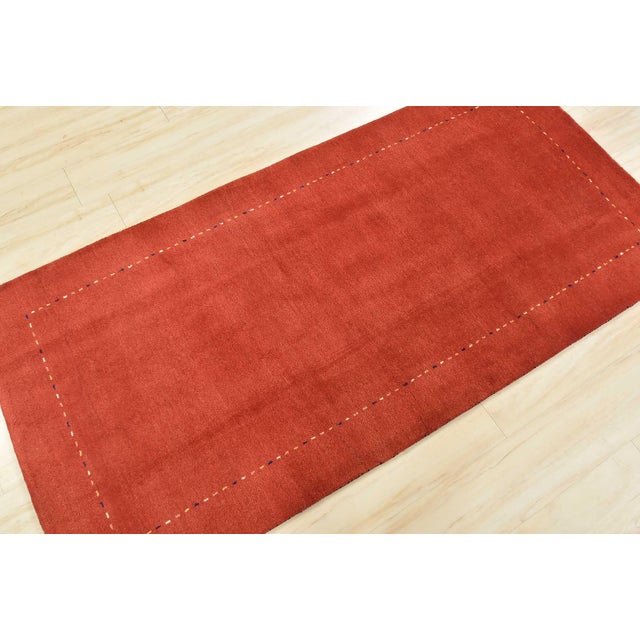 This contemporary Gabbeh runner is hand-knotted with an all-wool pile on a cotton foundation. This rug is new and in...