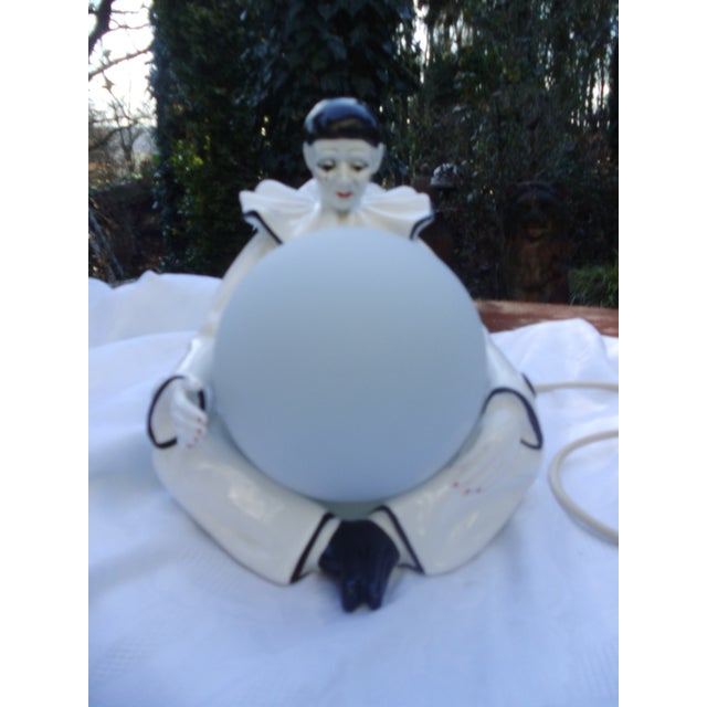 Is Pierrot weeping over the state of the earth he holds in his arms. An expressive, signed example from Italy. The opal...