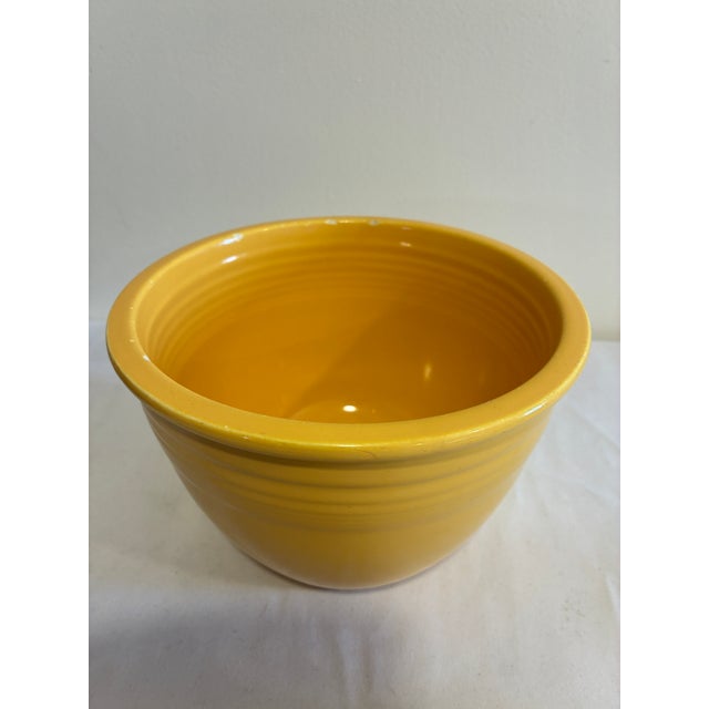 A vintage Fiesta #3 mixing bowl in the classic yellow glaze, featuring concentric ring detailing and a rolled rim. This...