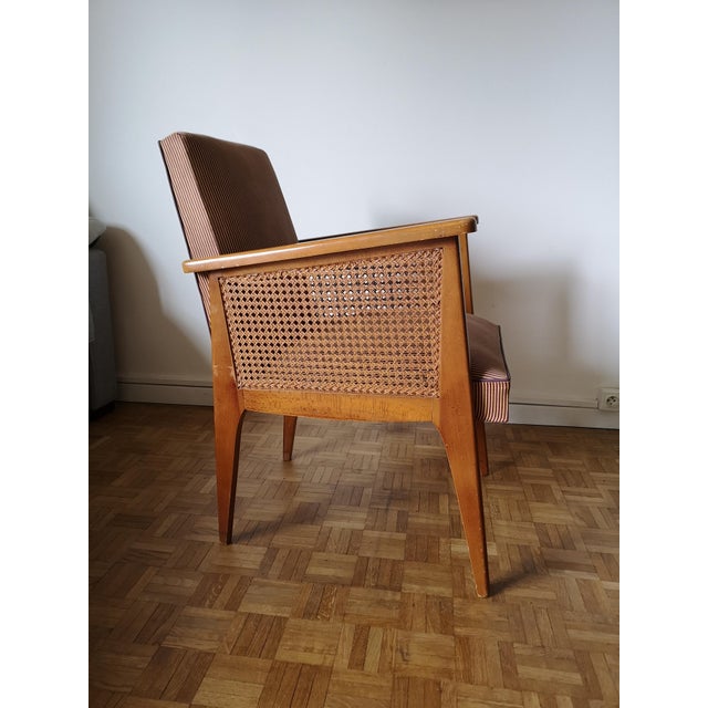 Vintage 1950s/1960s beechwood armchair with rattan armrests and compass legs. Its sprung seat is upholstered in a mustard...