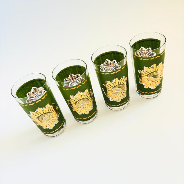 A set of 4 mid century highball tumblers. Each is decorated in olive green with a metallic gold starburst. Perfect for...