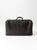 An antique black leather suitcase with a substantial form, heavily grained leather, aged brass hardware, and a leather-...