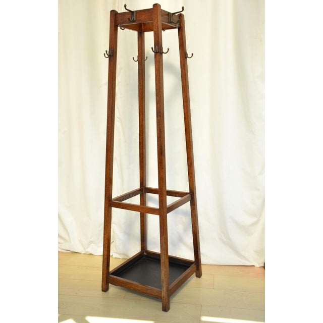 English antique Arts and Crafts coat stand, having four double coat and hat hook above eight single hooks on four square...