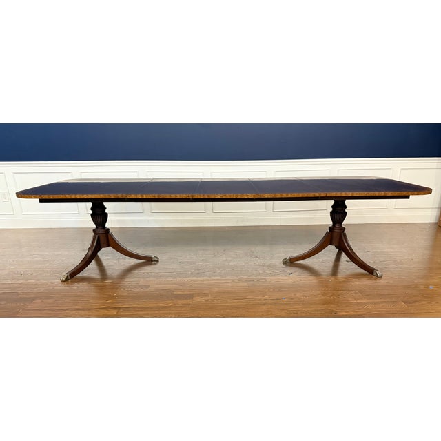 This is a multi-banded mahogany dining table by Leighton Hall. It features a field of cathedral mahogany with exotic...