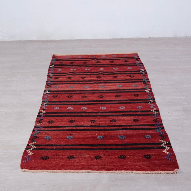 Original Kilim runner carpet, in shades of red with oriental decorations.