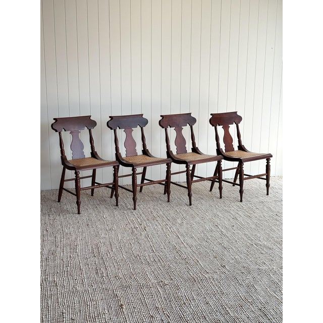This vintage set of dining chairs showcases shaped crest rails, turned spindle supports, and sculpted splat backs that...