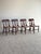 This vintage set of dining chairs showcases shaped crest rails, turned spindle supports, and sculpted splat backs that...