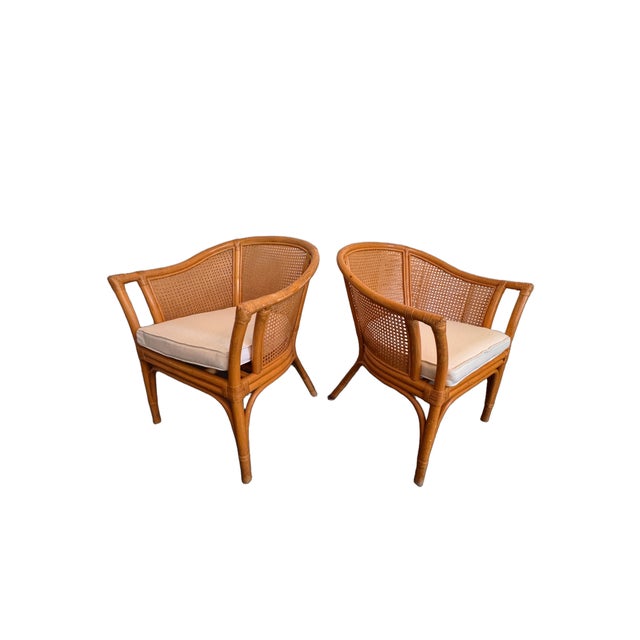 A beautiful pair of vintage McGuire style barrel back armchairs featuring the natural warmth and texture of rattan and...