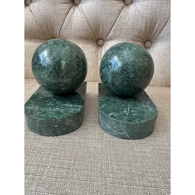 Pair of polished green stone bookends featuring spherical tops set on matching rectangular bases. Both decorative and...