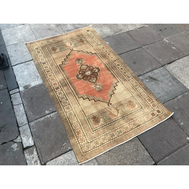 This is a vintage Turkish Oushak rug from the 1960s. The piece was hand-knotted.