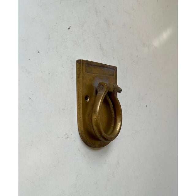 Heavy door hammer in patinated brass. Simple Bauhaus/Art Deco styling. It is suitable for both doors and gates. Vacant...