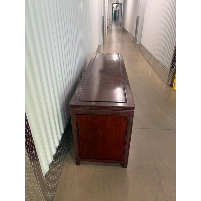 This is a stunning solid rosewood credenza. It features carved Asian symbols into the wood for pulls. There is a central...