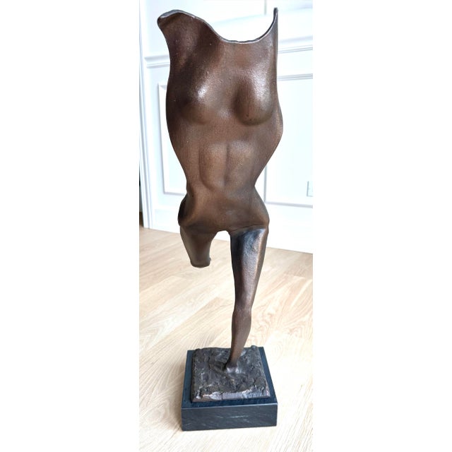A gorgeous vintage modernist sculpture depicting an abstract female figure in fluid motion. Cast in bronze and mounted on...