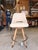Contemporary counter stool featuring a clean, minimalist silhouette upholstered in smooth cream leather. The gently curved...