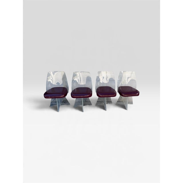 A stunning set of four vintage Hollywood Regency Lucite swivel dining chairs featuring substantial ½-inch-thick clear...