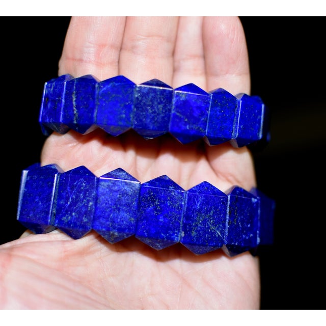A stunning set of handcrafted bracelets composed of individually carved, faceted lapis lazuli links, showcasing the...