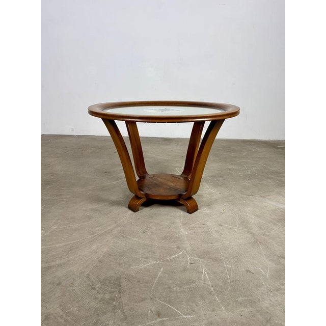 An elegant example of 1940s Art Deco design, this coffee table features a sleek glass and mirrored top that reflects light...