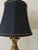 Elevate any room with this striking vintage table lamp featuring a dramatic black lacquered column, warm gold accents, and...