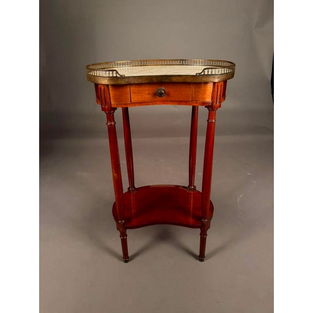 Elegant French craftsmanship meets timeless Louis XVI styling in this exceptional 19th-century kidney-shaped side table,...