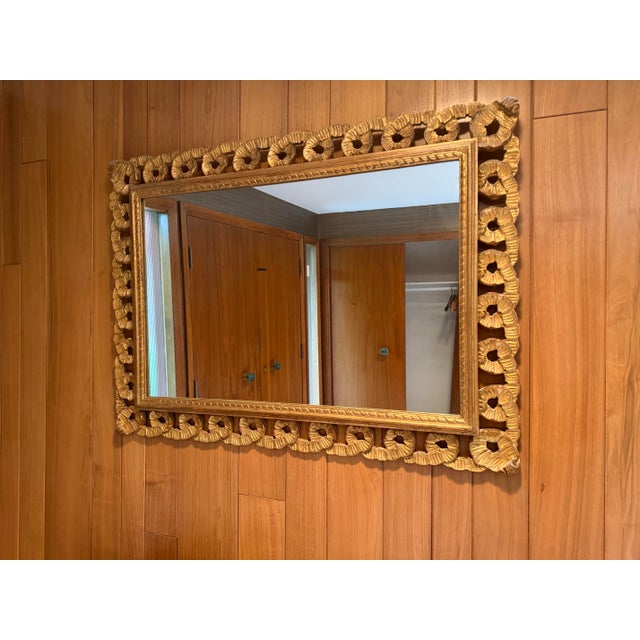 Description direction: Striking vintage carved giltwood wall mirror featuring an ornate scrolling frame with a beautifully...