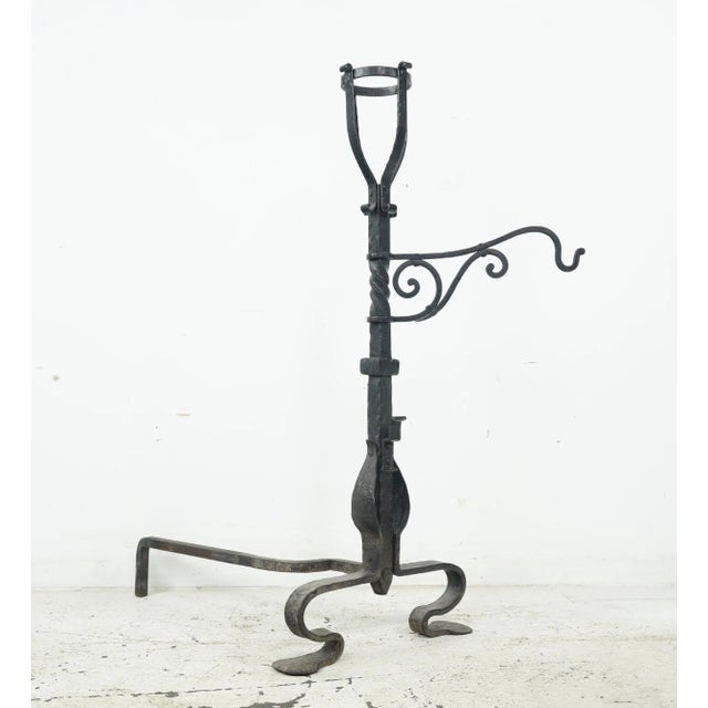 Enhance your fireplace with this pair of antique French wrought iron andirons. Elegant hooks and a poker hanger accompany...