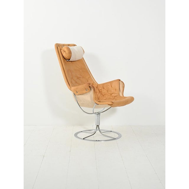 Iconic Swedish armchair from the 1960s and 1970s, featuring a chrome base and tufted seat with headrest: futuristic lines,...