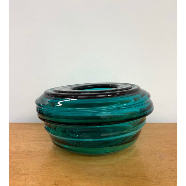 A sculptural vintage art glass bowl in a rich emerald-teal tone, featuring a low rounded form with thick, heavily molded...