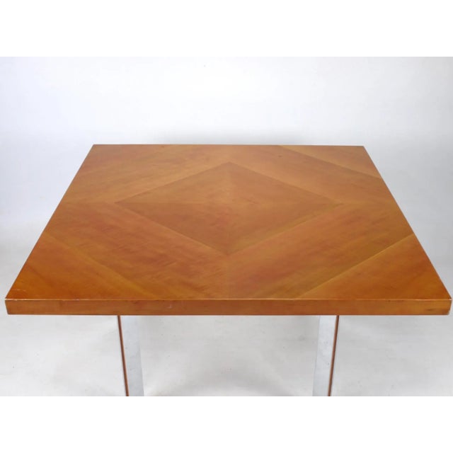 A square table by British design and company Gordon Russell. The table top is manufactured in pear wood and the legs are...