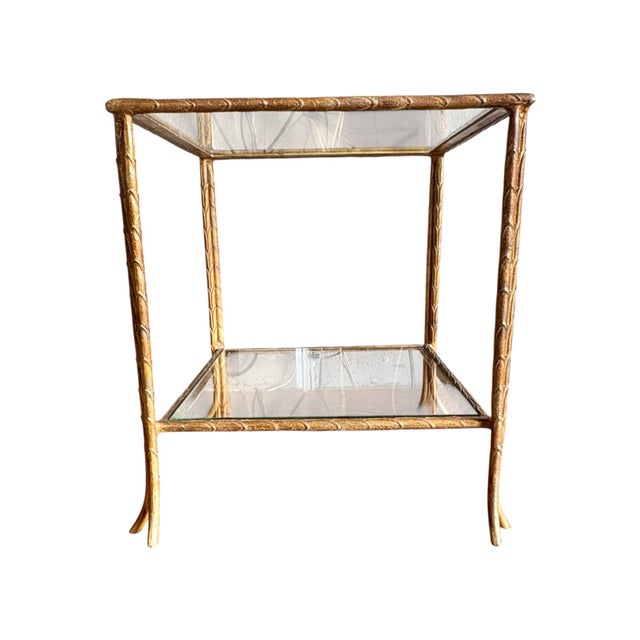 Lovely vintage table with 2 glass shelves and a gilt painted finish. Great between two chairs in a living room!