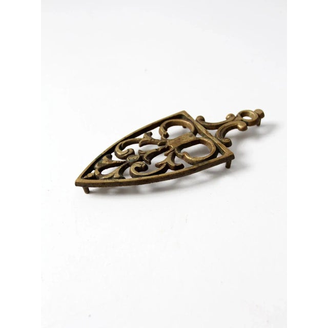 This vintage brass trivet brings a touch of charm and warm metallic shine to your kitchen. The beautifully cast design...