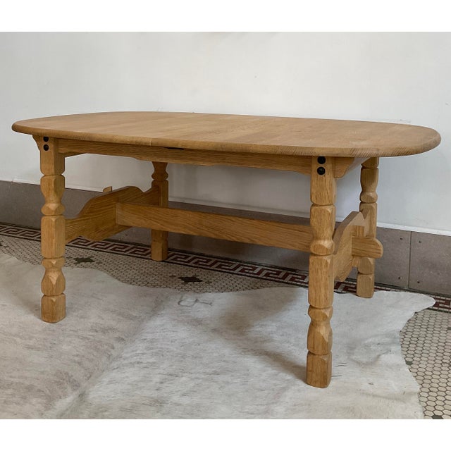 Bring a striking piece of Scandinavian design into your home with this exceptional 1970's Danish oak dining table, heavily...