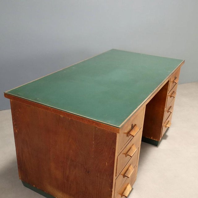 Desk with double column, side drawers, oak veneer, rubber top. Requires restoration. This piece is attributed to the...