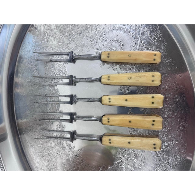 A charming set of five primitive antique forks with slender steel tines and pale, riveted handles. Their timeworn patina...