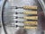 A charming set of five primitive antique forks with slender steel tines and pale, riveted handles. Their timeworn patina...