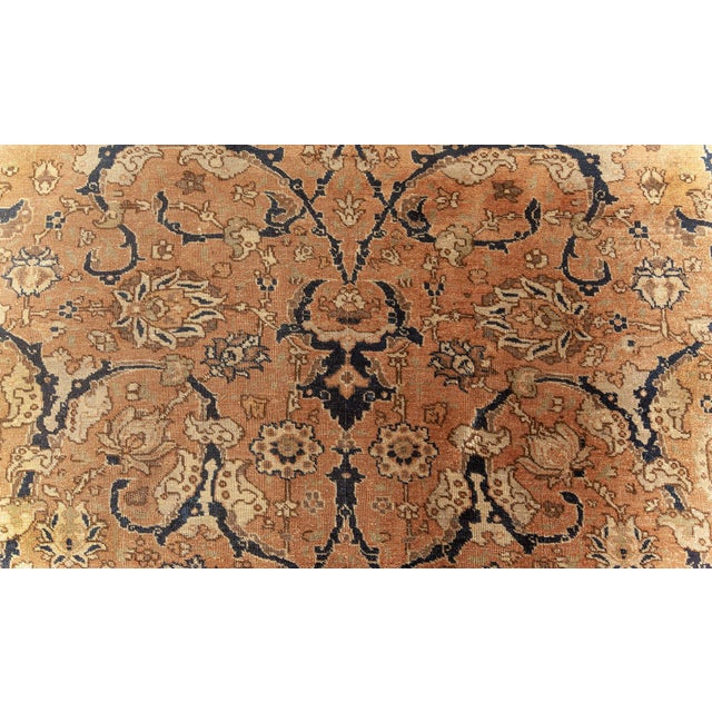 This turn of the century antique Persian Tabriz carpet features an all-over design of scrolling interlocking arabesques in...