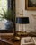 A handsome mid-20th-century brass bouillotte lamp with a tailored black tole shade and classic two-light configuration....