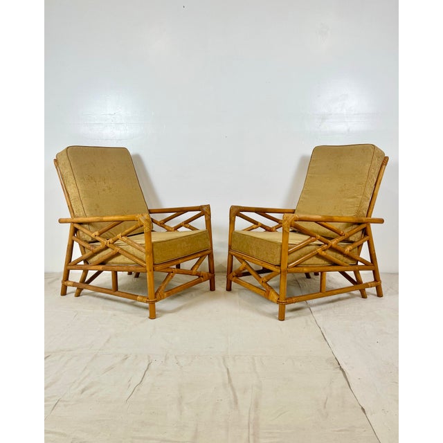 Vintage pair of rattan lounge chairs. Chinese chippendale fretwork designs on sides and front. Cane wrapped joints....