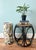 Handsome, vintage low rattan stool featuring a black finish, sculptural bent-rattan frame, and natural woven cane top. The...
