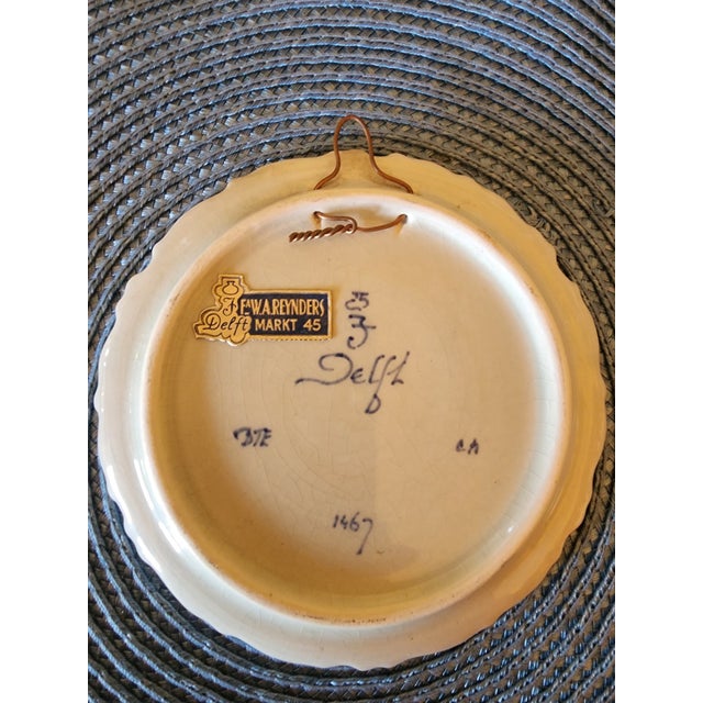 This is a Royal Delft blue and white hand-painted pottery plate from 1956, featuring a Dutch windmill scene. The back of...