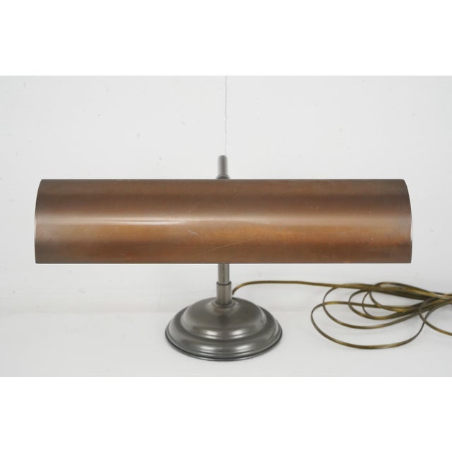 Industrial style banker's desk lamp with a weighted steel circular base and an adjustable brass rectangular shade. The...