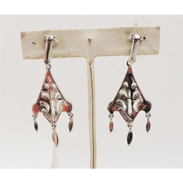 This is part of Chairish’s Costume Jewelry assortment. 1960s rhodium plated rhinestone chandelier earrigns with three...