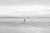 This timeless black and white beach photography print features a male figure wading into the water, eager for a swim in...